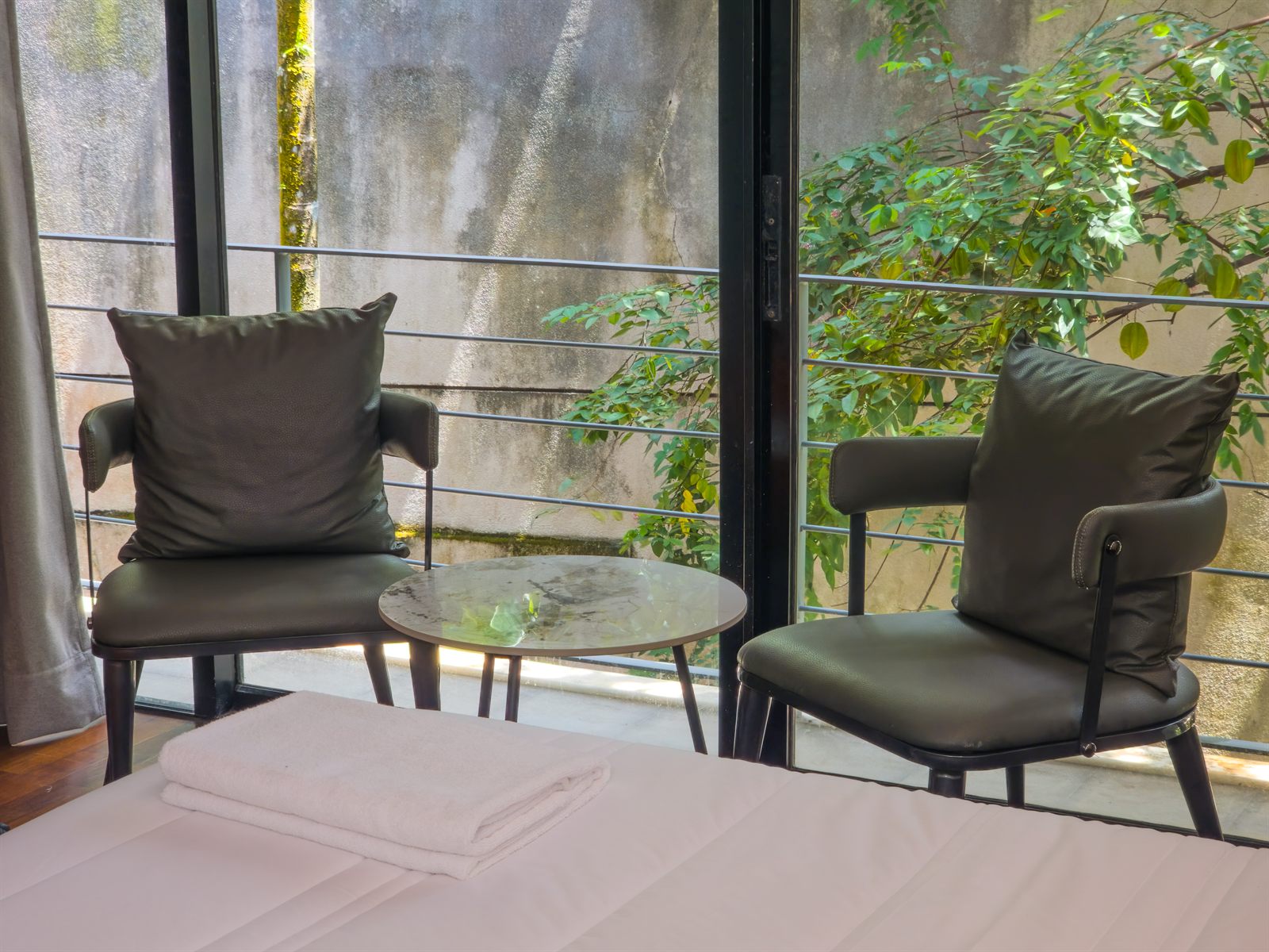 Superior Room balcony chairs beside the bed